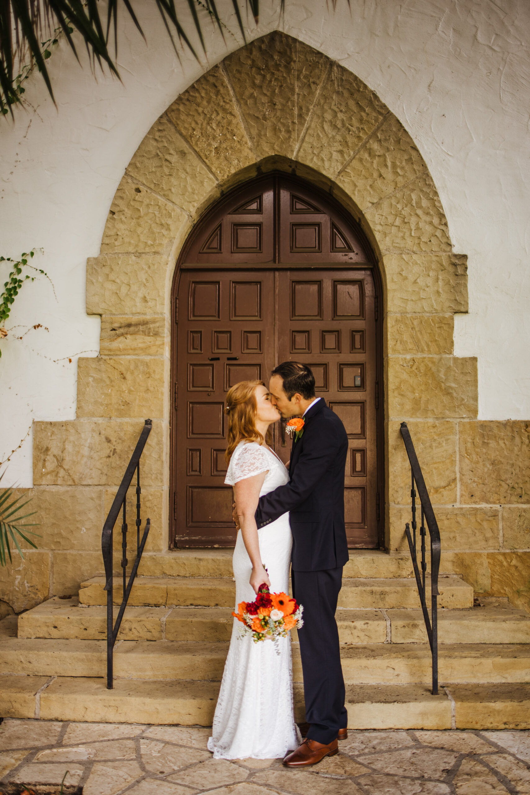 bride and groom kiss in front of door at SB County Courthouse