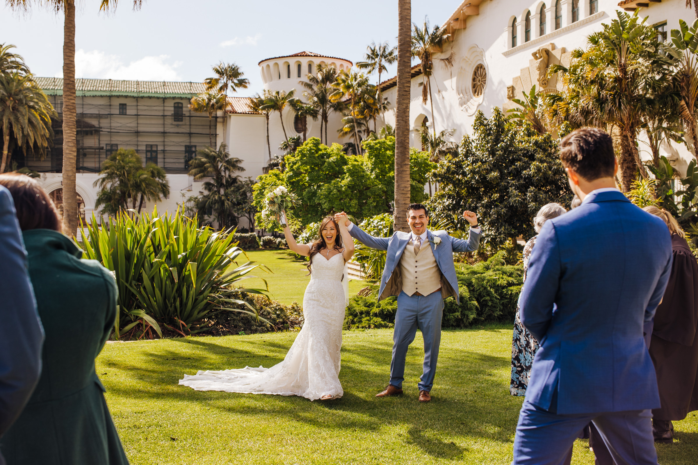 bride and groom cheer with guests after wedding ceremony