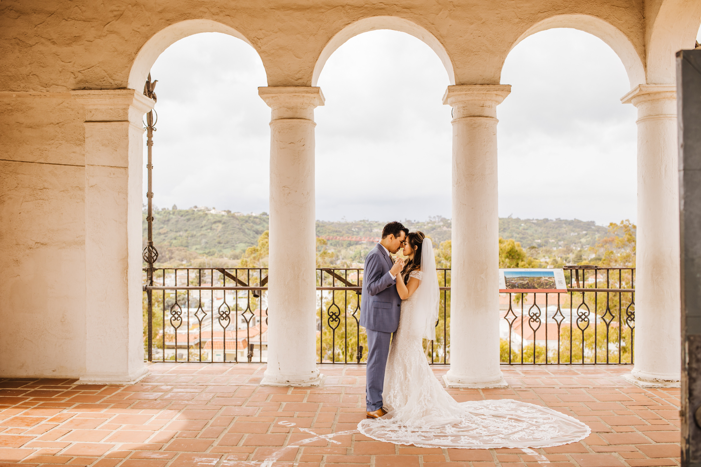 bride and groom standing with foreheads touching on balcony at SB County Courthouse