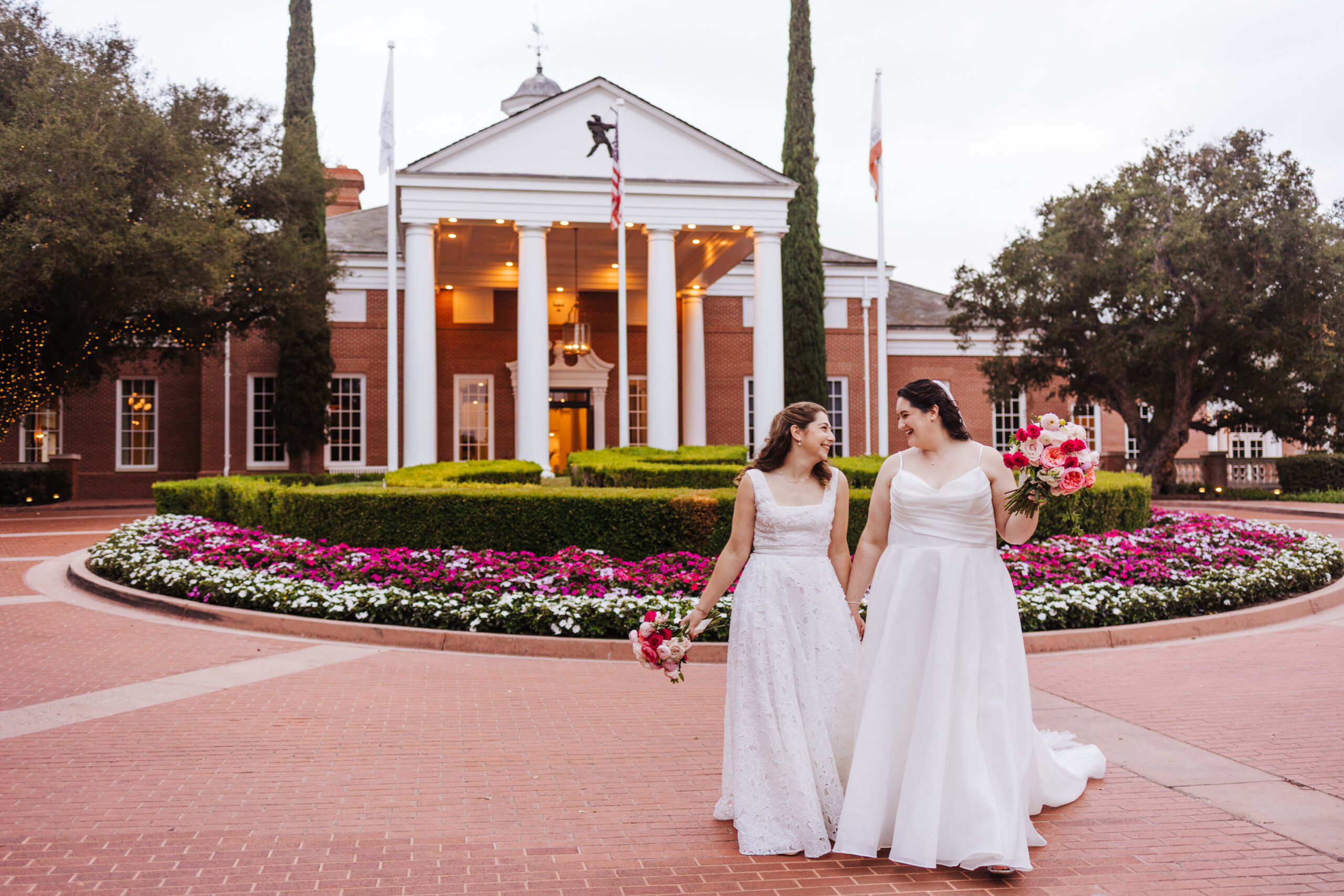 Two brides at the front entrance of Sherwood Country Club