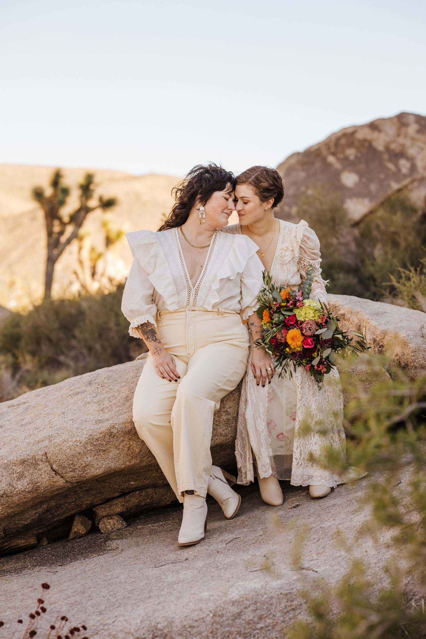 Two brides sitting in Joshua Tree