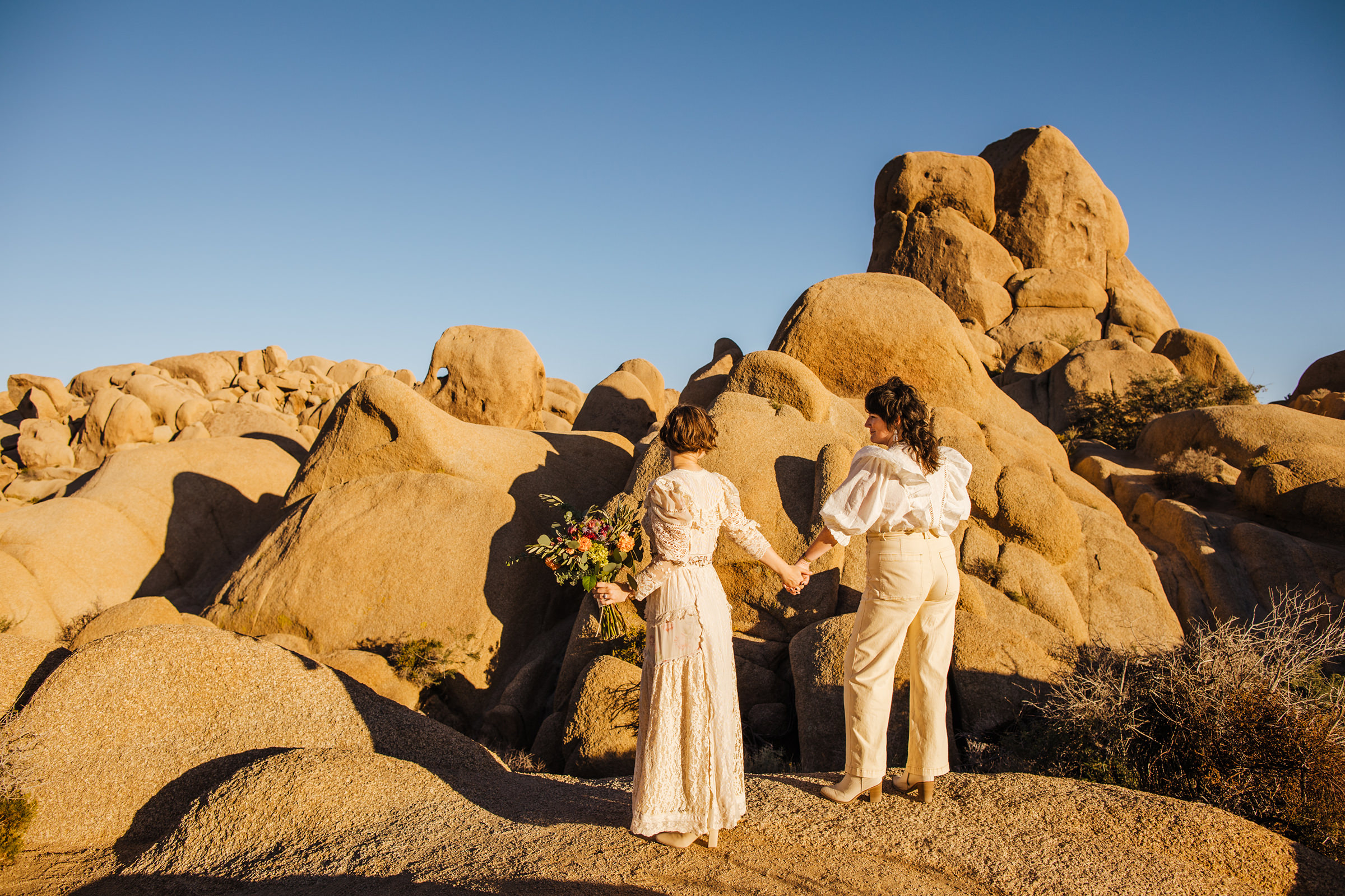 Brides in Joshua Tree with boulders and sunshine