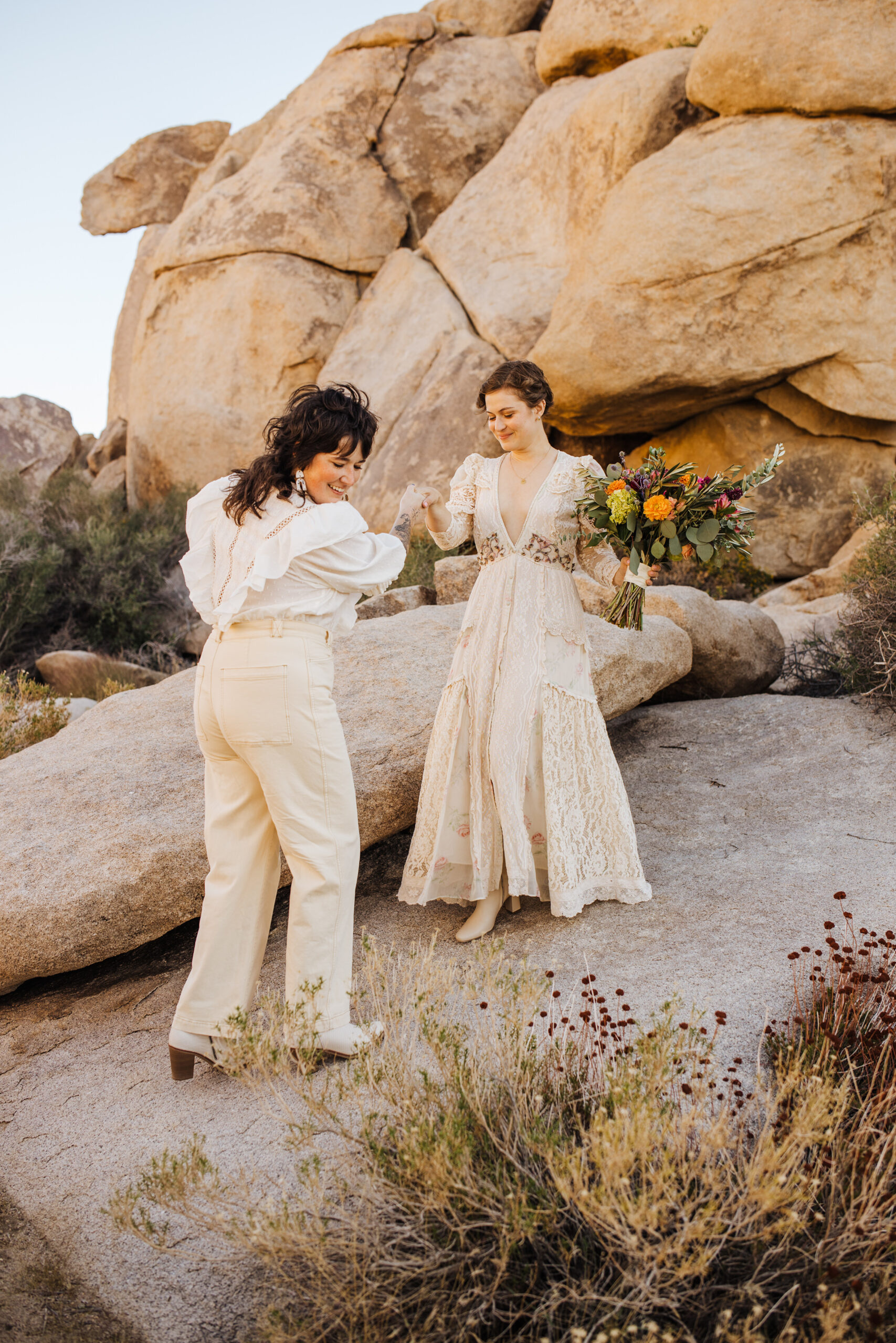 Brides walking down sloped rock