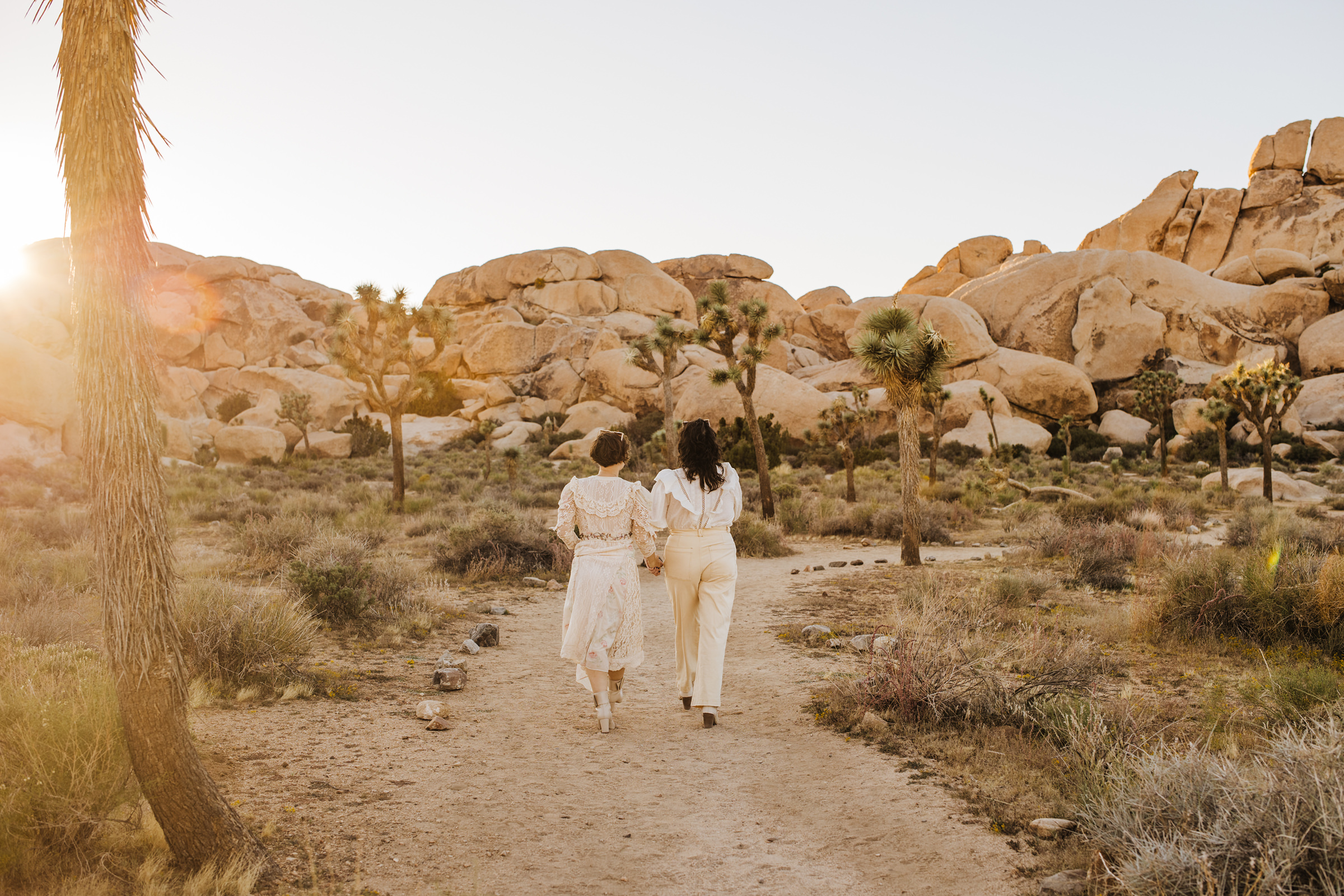 Two brides walking on path in Joshua Tree National Park